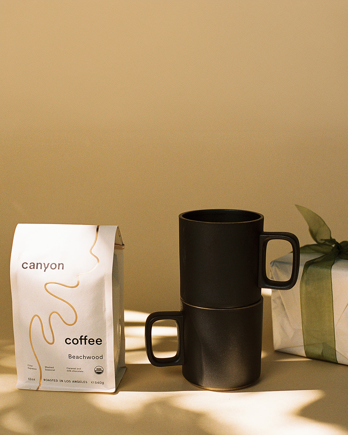 The Host Gift Bundle by Canyon coffee featuring a pair of tan Hasami mugs and a bag of organic coffee