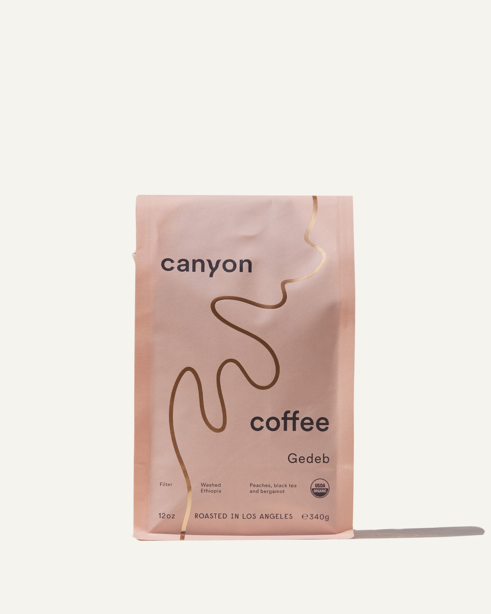 A bag of Gedeb Whole Bean coffee by Canyon Coffee with gold foil
